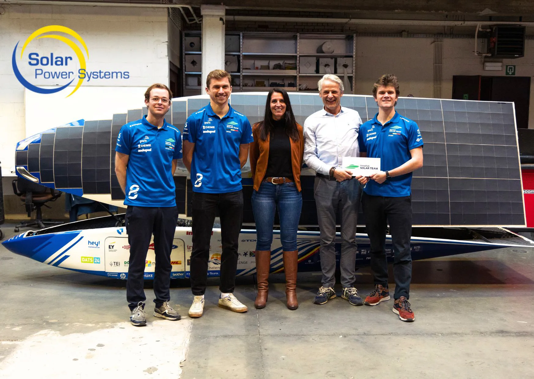 Luc Martens van Solar Power Systems poseert samen met het team van Innoptus Solar Team voor hun zonnewagen.