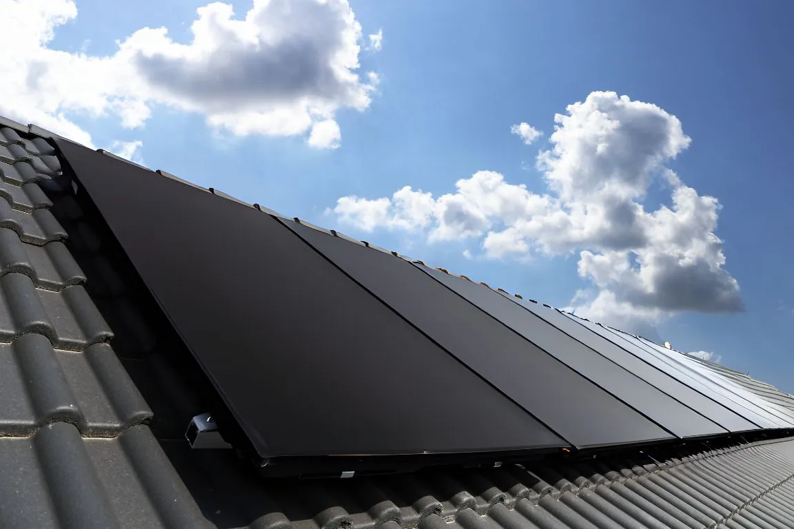 Een dak vol zonnepanelen van Solar Power Systems onder een blauwe lucht.
